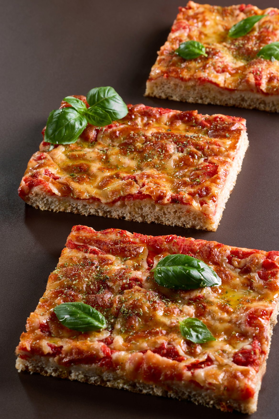 Trancio di pizza al taglio con pomodoro, formaggio filante e basilico fresco