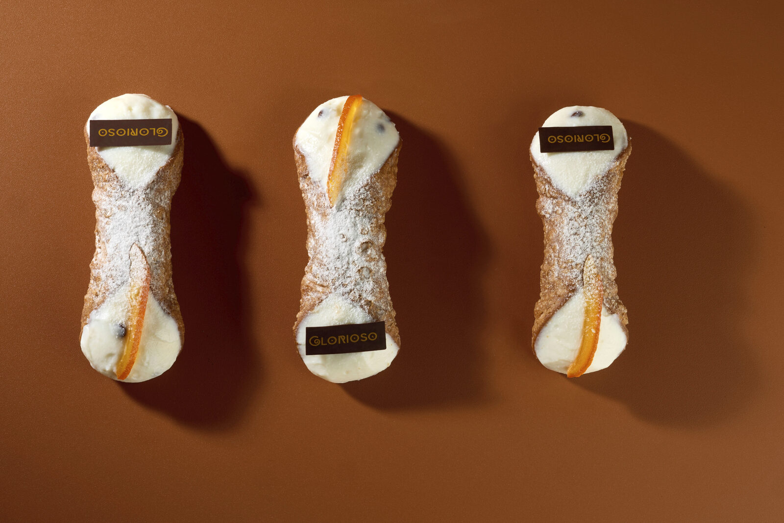 Tre cannoli siciliani farciti con crema e scorza d'arancia candita