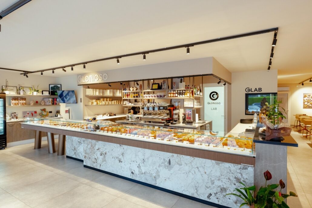Il bancone della pasticceria con l'insegna Glorioso e l'ingresso del laboratorio GLAB