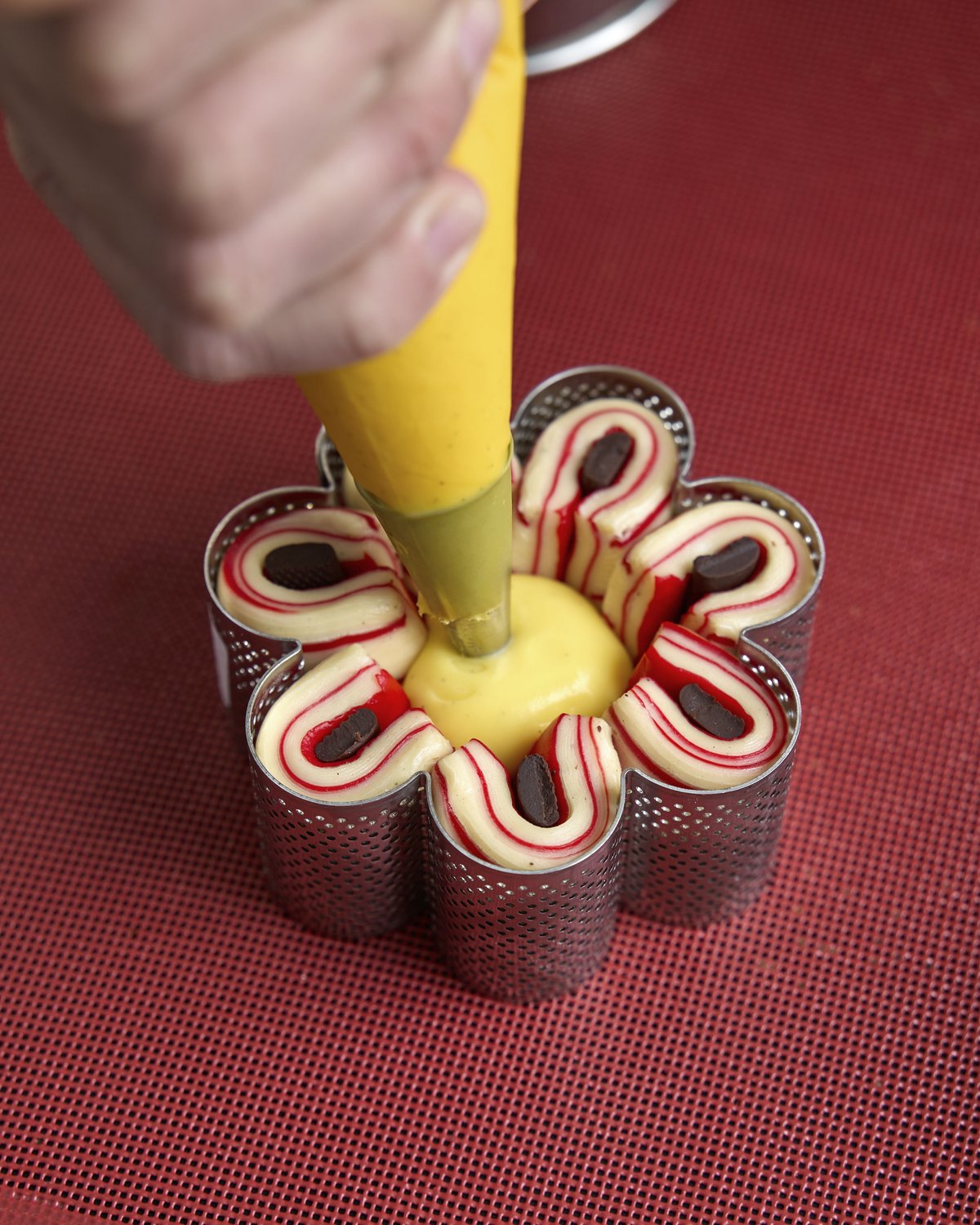 Decorazione a mano di monoporzioni a forma di fiore con crema e cioccolato