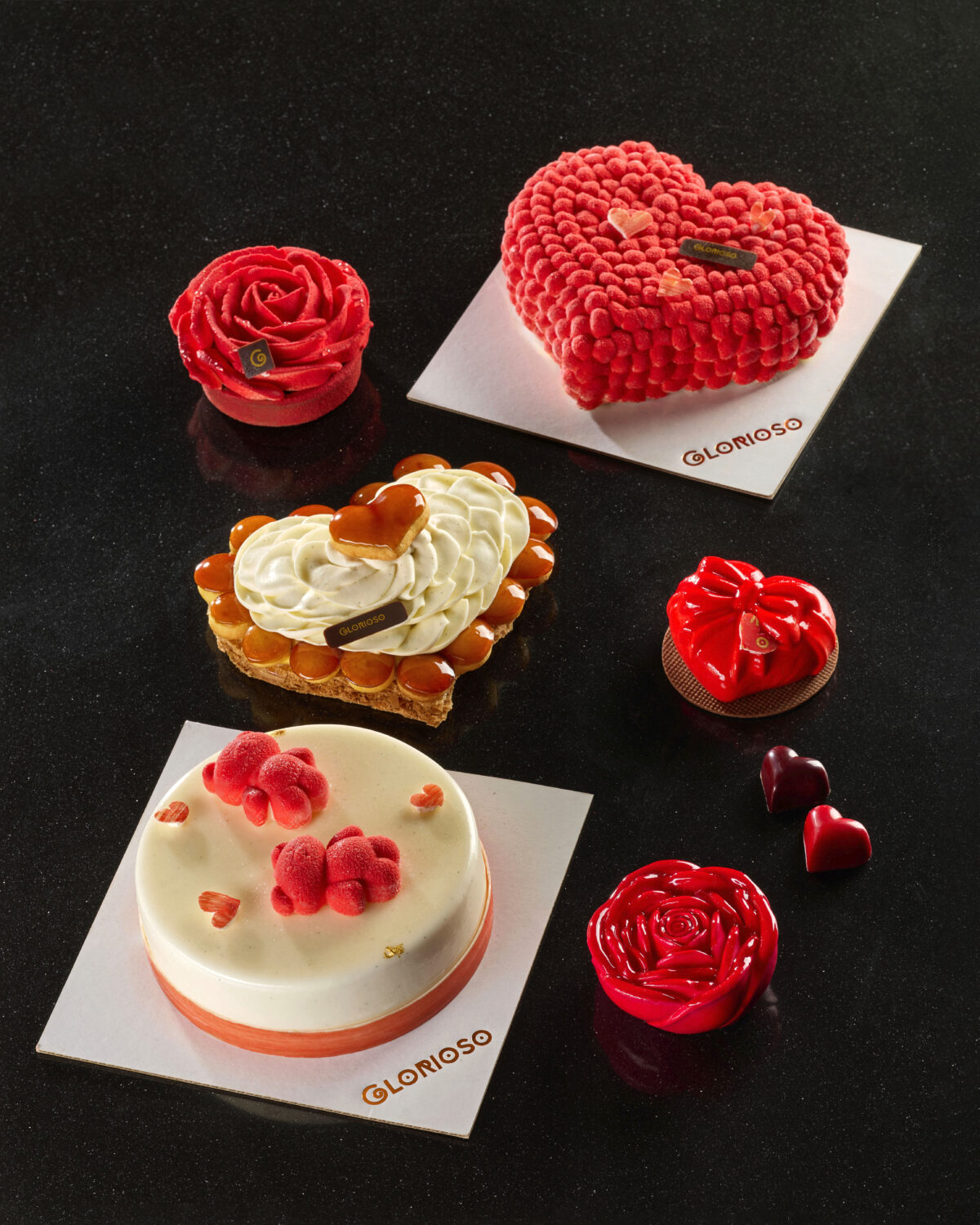 Assortimento di dolci di San Valentino: rosa, cuore vellutato, fiocco, mignon e torta ai lamponi