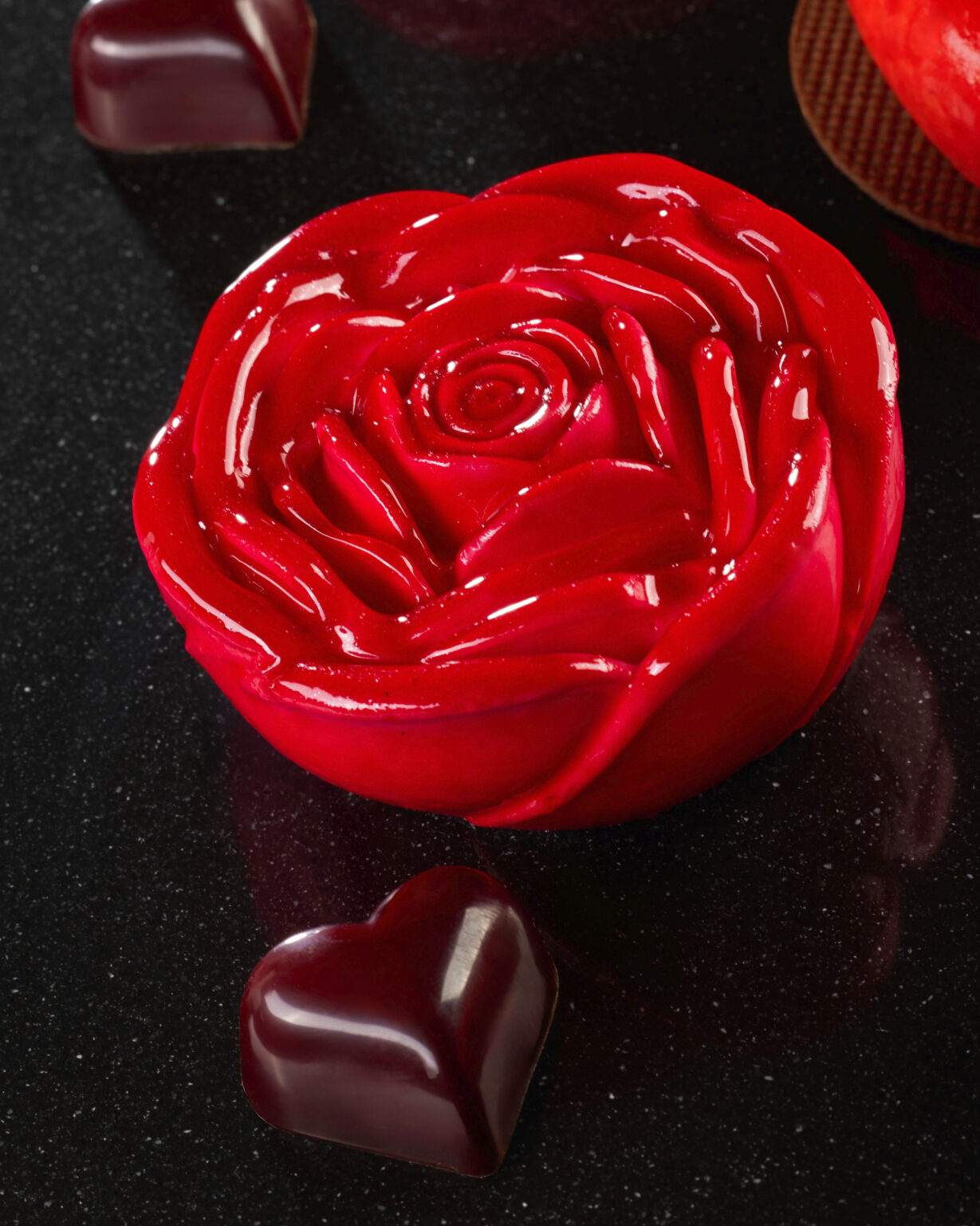 Dettaglio di una rosa in glassa rossa con cioccolatino a forma di cuore