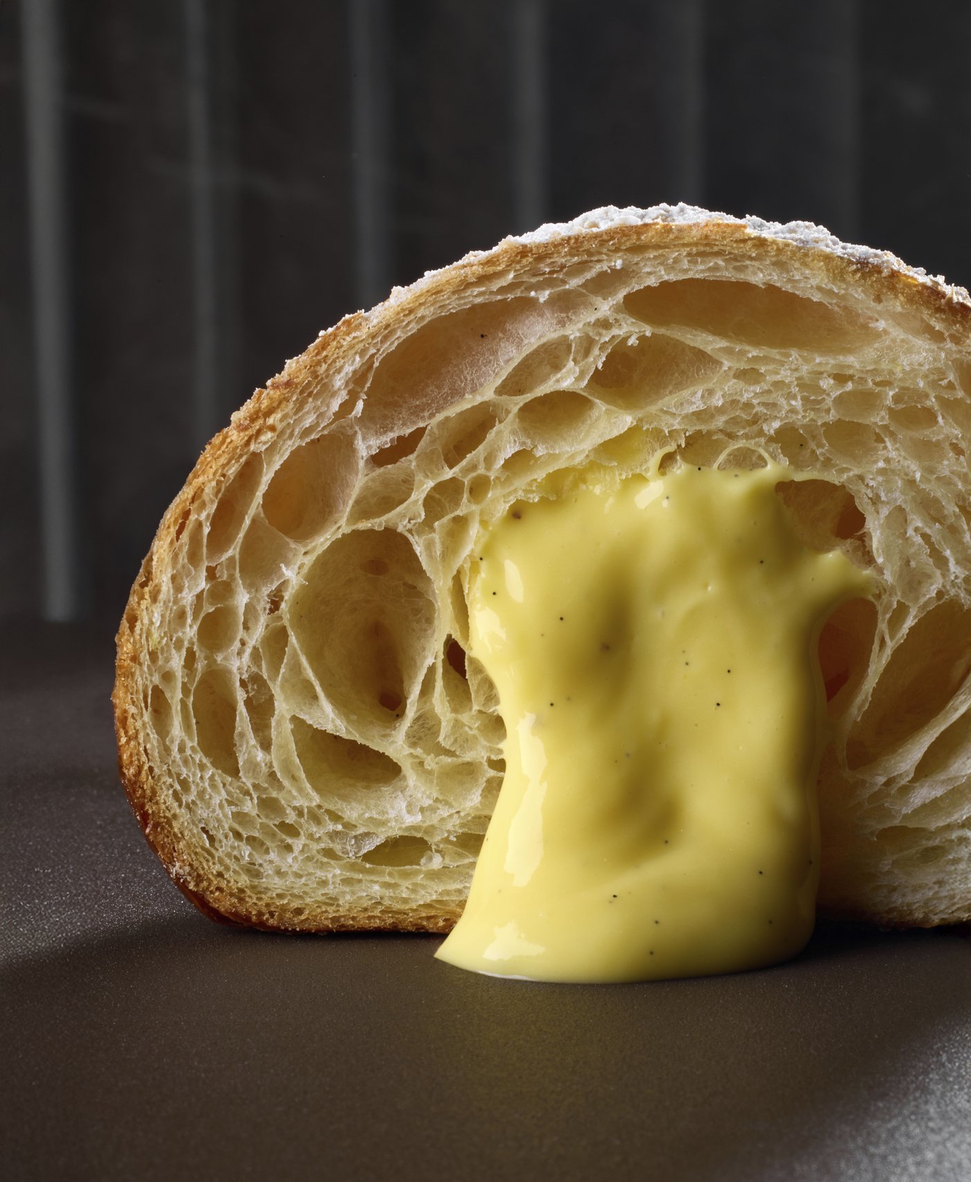 Cornetto sfogliato tagliato a metà, farcito con crema pasticcera alla vaniglia